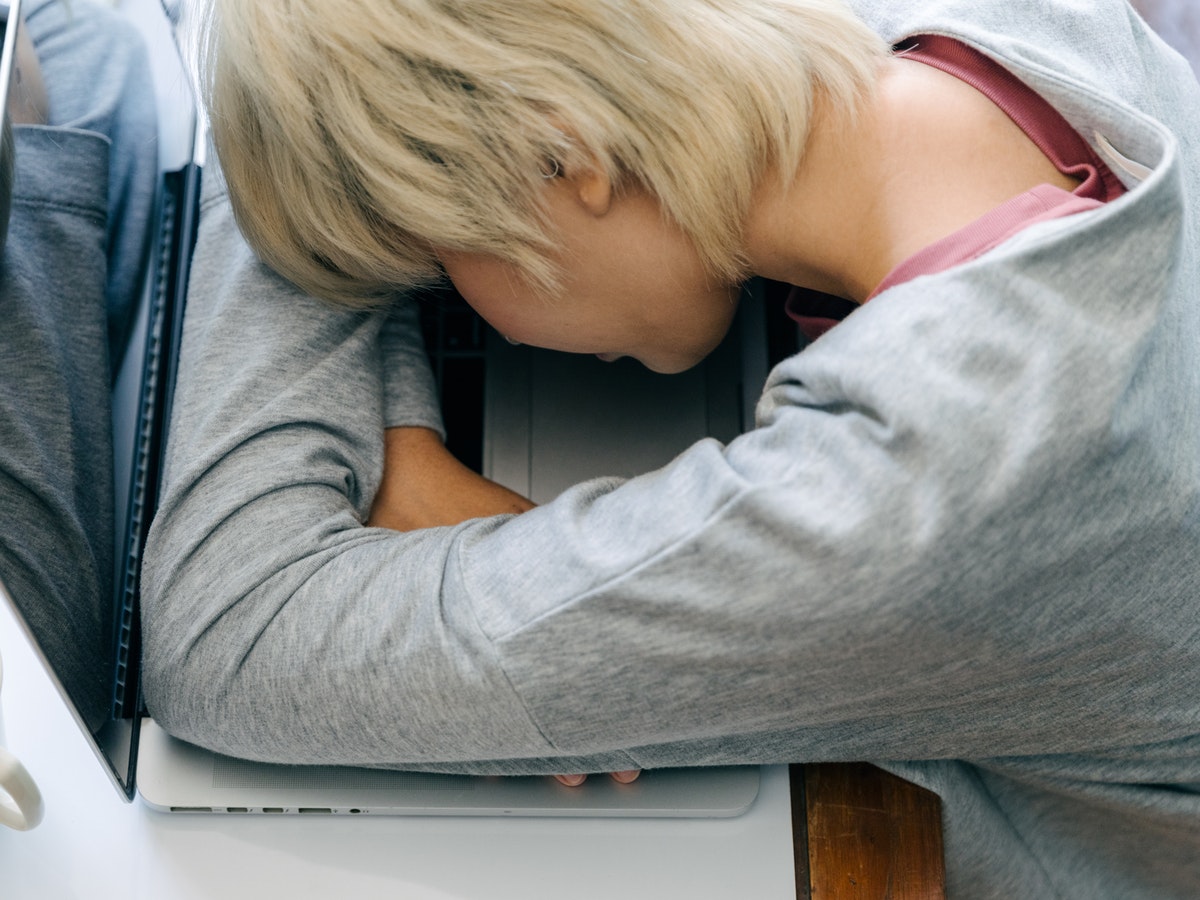 Woman Leaning on Her Table over a Laptop